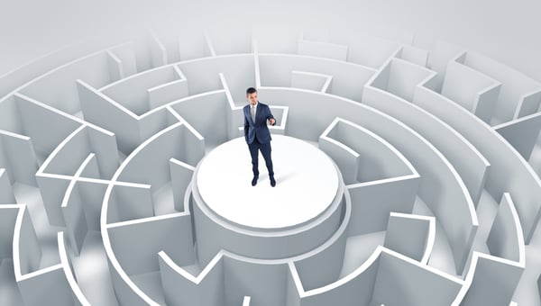 Businessman standing on the top a maze and looking through